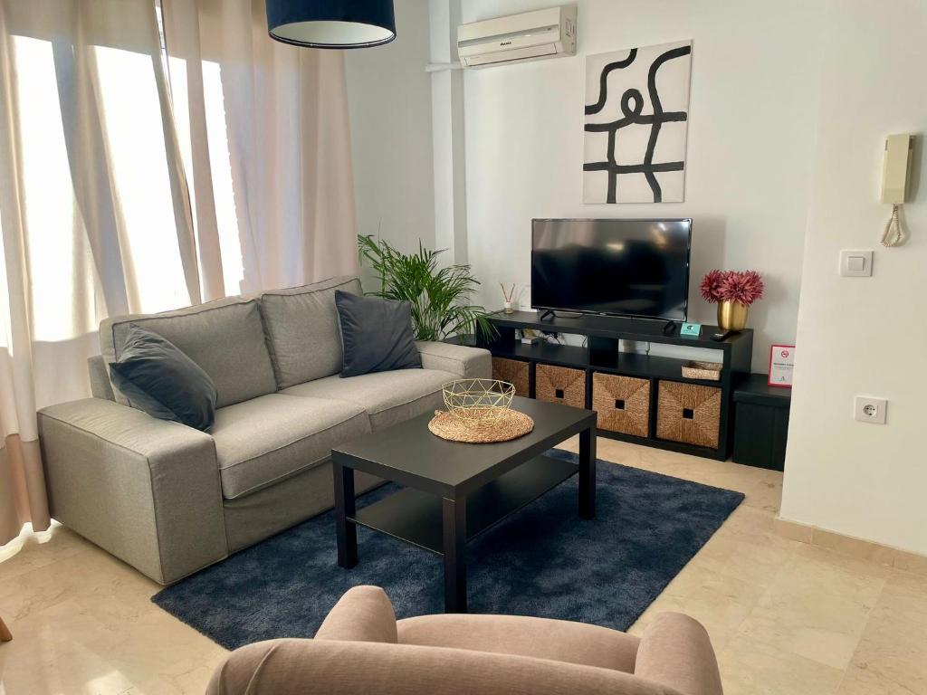 a living room with a couch and a tv at La Repera Jaén in Jaén