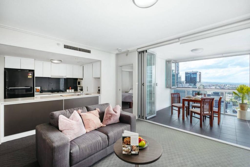 a living room with a couch and a table at Great Value CBD 2 Beds Apt Free Carpark Pool and Gym in Brisbane
