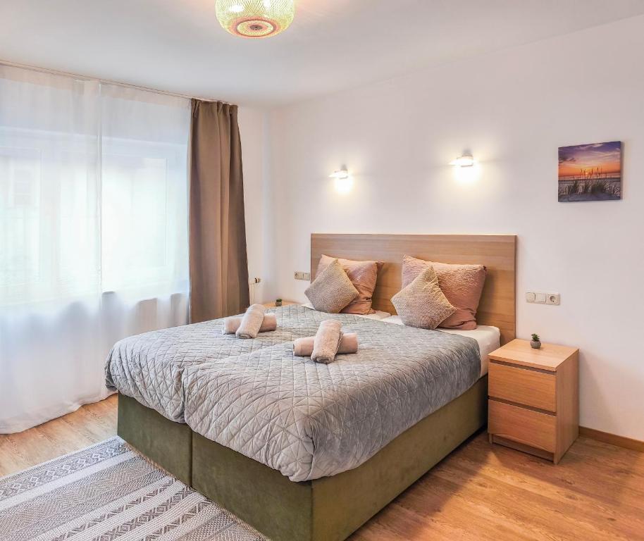 a bedroom with a bed with two stuffed animals on it at Luxus Apartments im Zentrum Nürnbergs, nahe Messe, mit Balkon & Parkplatz, nähe Playmobilfunpark, Self-Check-in in Nuremberg