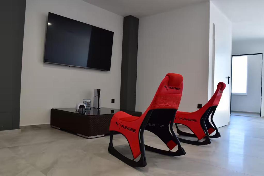 2 sillas rojas en la sala de estar con TV en AAAAqsd, en Paje