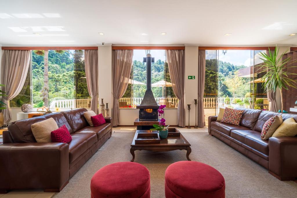 a living room with two couches and a table at Pousada Grandchamp - Campos do Jordao in Campos do Jordão