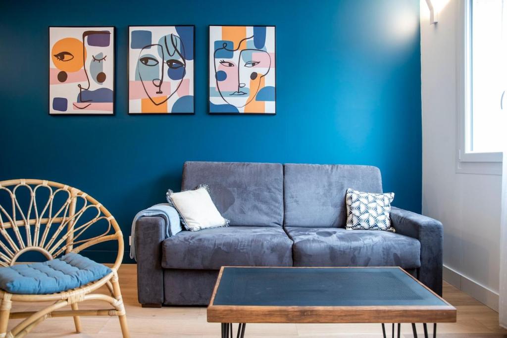 - un salon avec un canapé et quatre peintures murales dans l'établissement Bel appartement entre Campus 1 et Vaugueux, à Caen