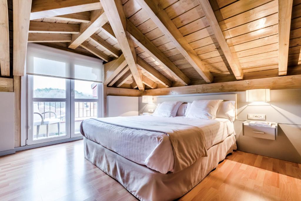 a bedroom with a large bed and a large window at Hotel Nagusi in Murguía