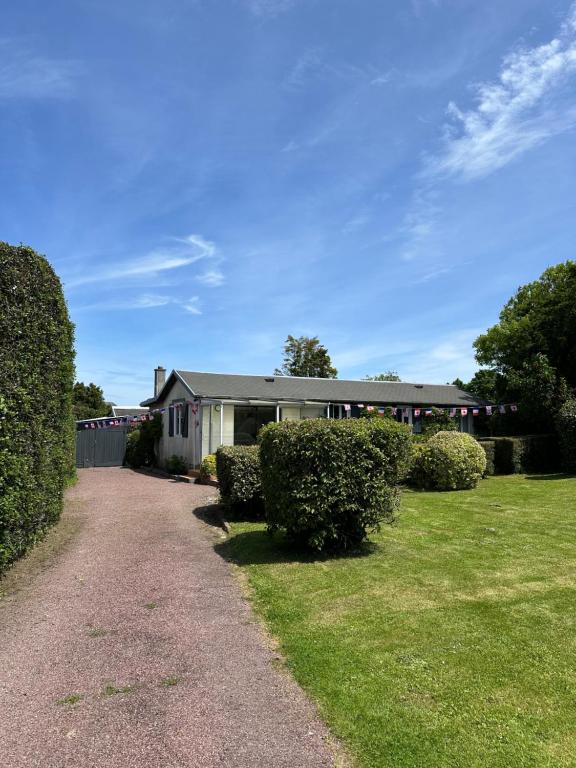 a house with hedges in front of a yard at Little Omaha in Vierville-sur-Mer