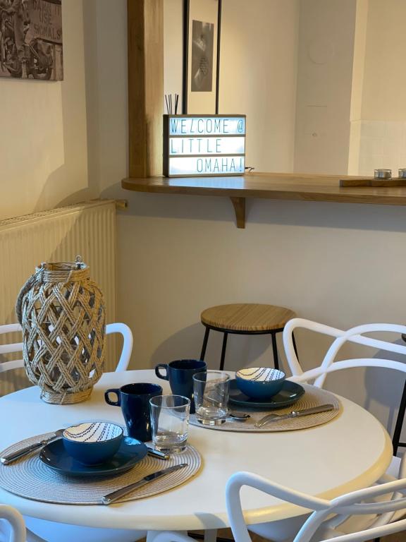 a white table with plates and bowls on it at Little Omaha in Vierville-sur-Mer