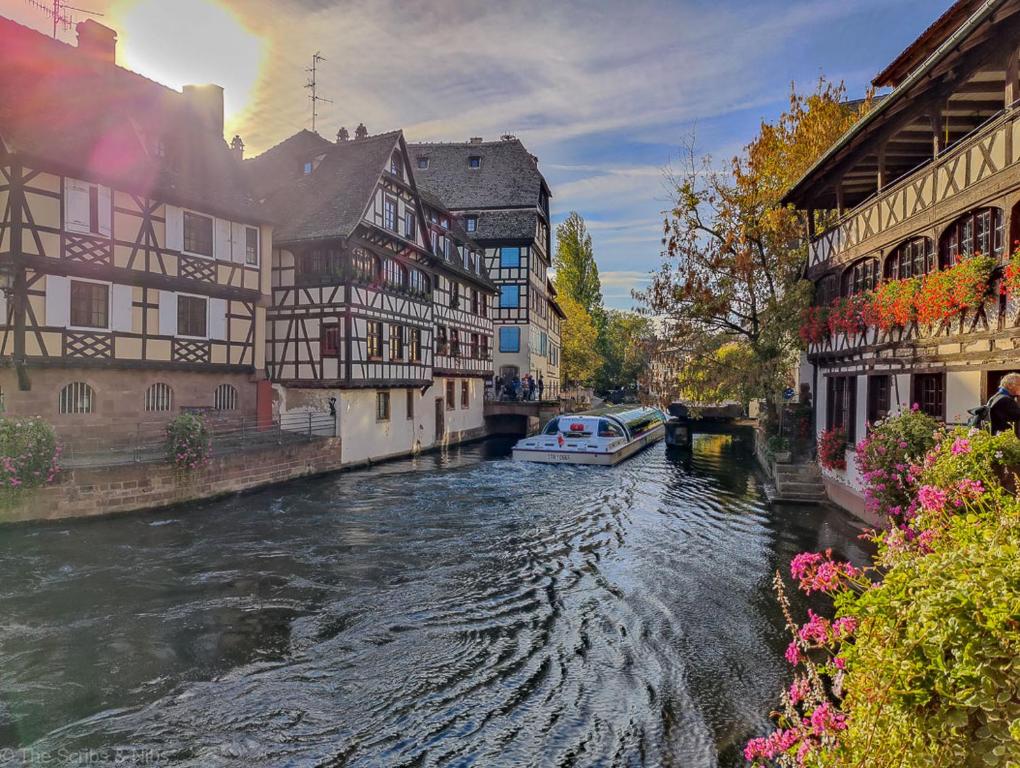 une rivière dans une ville avec des bâtiments et un bateau dans l'établissement Centre Strasbourg, à Strasbourg