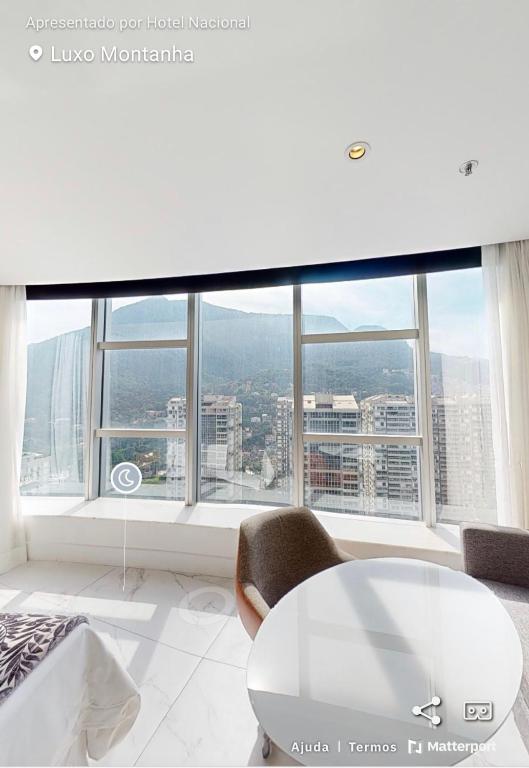 a white room with a table and chairs and windows at Hotel Nacional in Rio de Janeiro