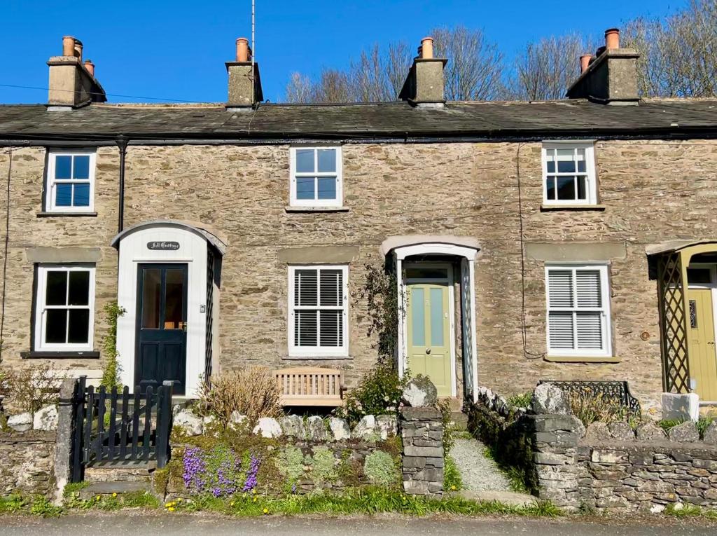 a brick house with a bench in front of it at Fellfoot Cottage in the Lake District in Staveley