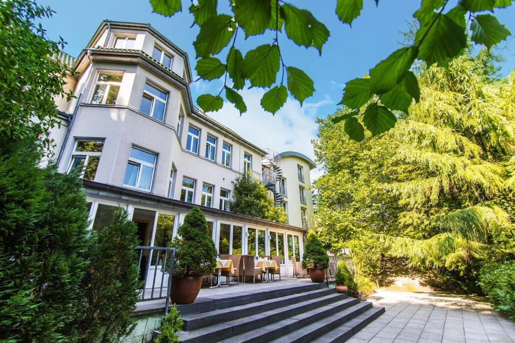 an exterior view of a building with plants and trees at Hotel Das Lola in Essen