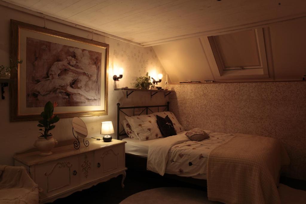 a bedroom with a bed and a table with lights at B&B De Zwerver in Oldehove