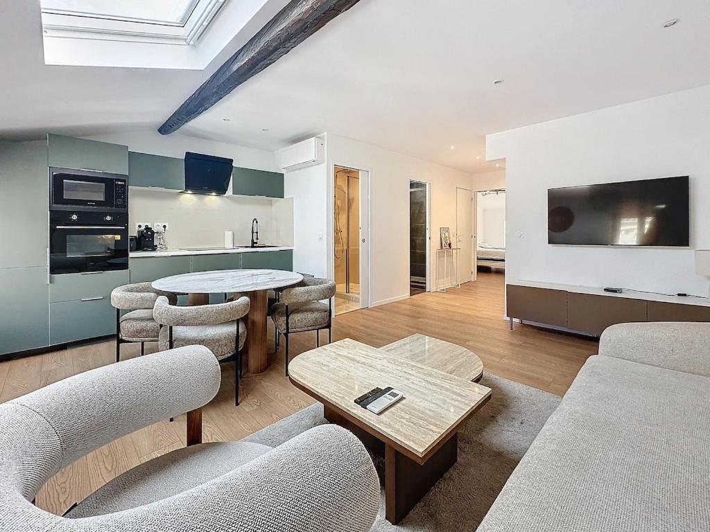 un salon avec une table et des chaises et une cuisine dans l'établissement 54m2 hypercenter, face Palais des Festivals, à Cannes