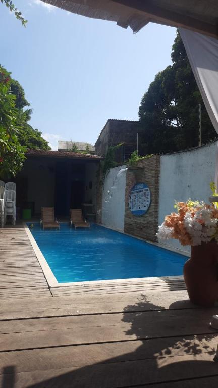 a swimming pool with a wooden deck and a swimming pool at casacop30belem in Belém