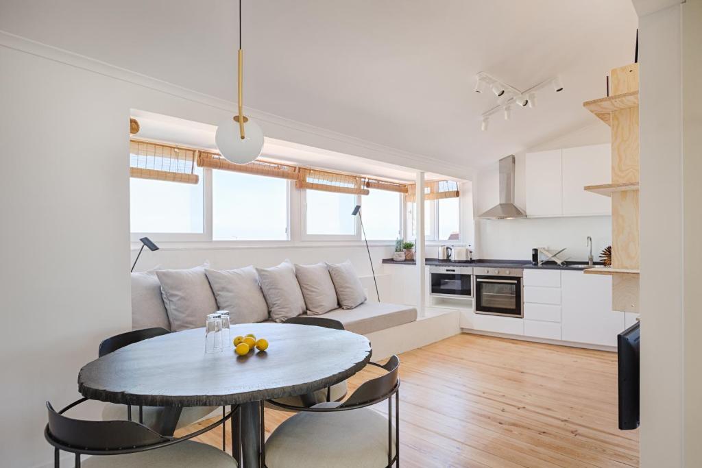 a kitchen and a living room with a table and chairs at Romantic Gem in Graça in Lisbon