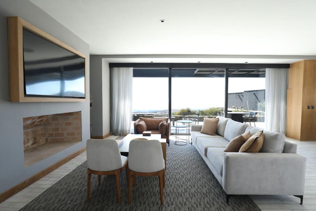 a living room with a white couch and a fireplace at Puesto del Indio in Mendoza