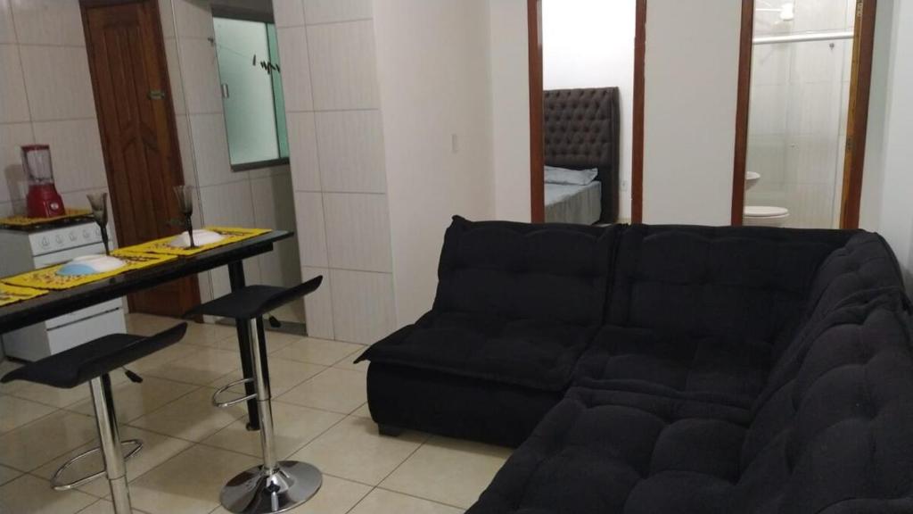 a living room with a black couch and a table at Apartamento 102 Encantador in Vitoria da Conquista in Vitória da Conquista