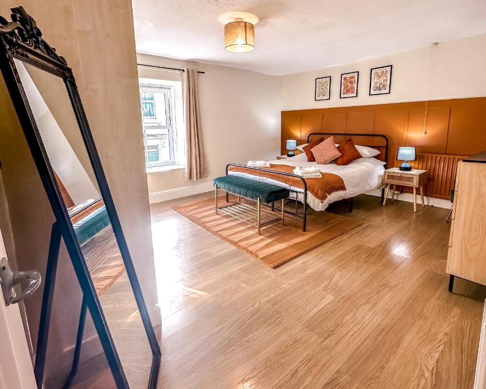 a bedroom with a bed and a mirror at Bourne Cottage, Cozy 3 Bed Haven, Sleeps 7, Pets Stay Free, Central Stay, Xbox Fun in Castleton