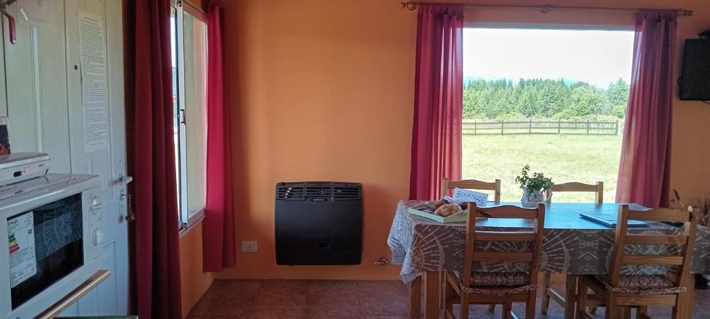 una sala da pranzo con tavolo e finestra di Cabaña Las Lavandas a Trevelin