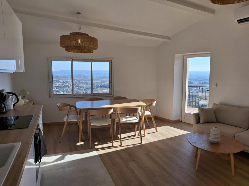 une cuisine et un salon avec une table et des chaises dans l'établissement Appartement panoramique, clim, terrasse, 6 personnes, à Lacoste