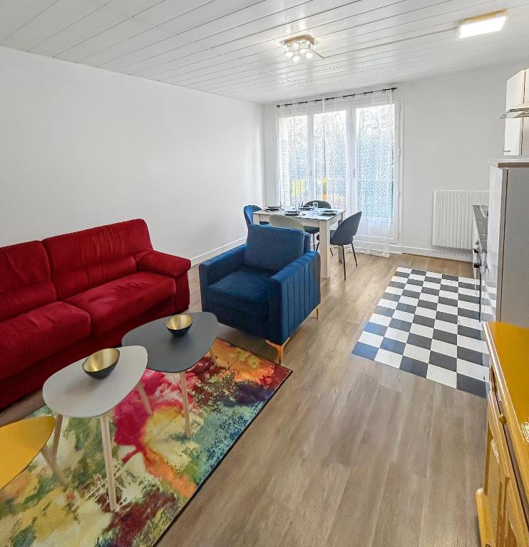 un salon avec un canapé rouge et une table dans l'établissement Charme et calme proche centre, à Quimper