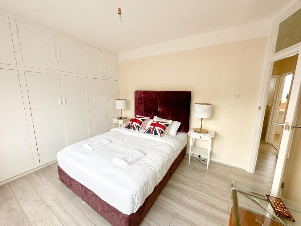 Un dormitorio con una cama grande con almohadas rojas y blancas. en Limehouse Apartment, en Londres