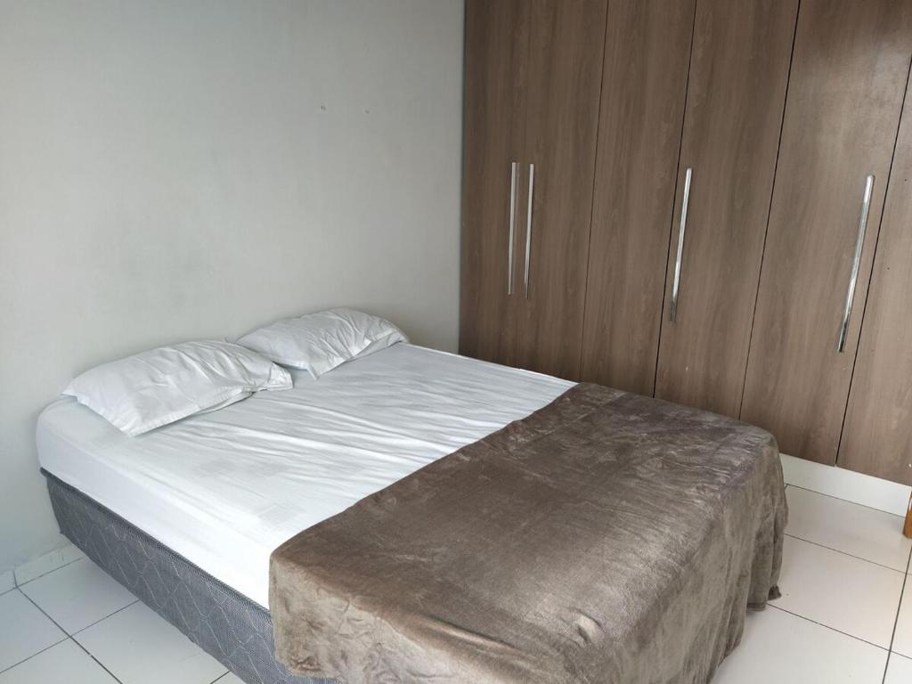 ヴィトリア・ダ・コンキスタにあるApartamento 305 Encantador Centro de Conquistaのベッドルーム(ベッド1台、木製キャビネット付)