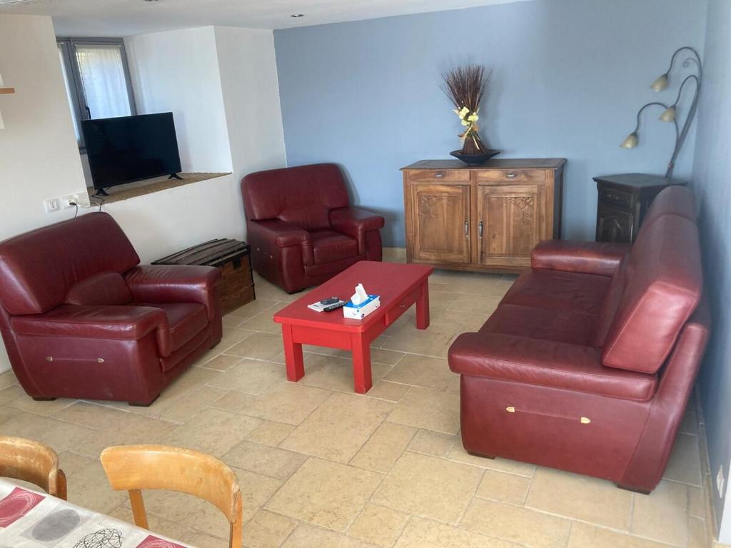 a living room with leather furniture and a tv at Gite de l'Entressac in Pradelles