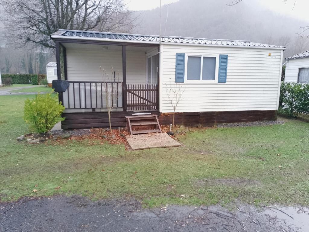 une petite maison blanche avec un banc dans la cour dans l'établissement ROEVMi, à Gère-Belesten