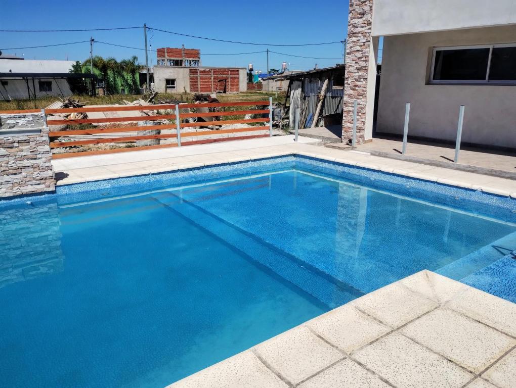 una gran piscina azul con una valla de madera en Complejo Marlu, en Federación