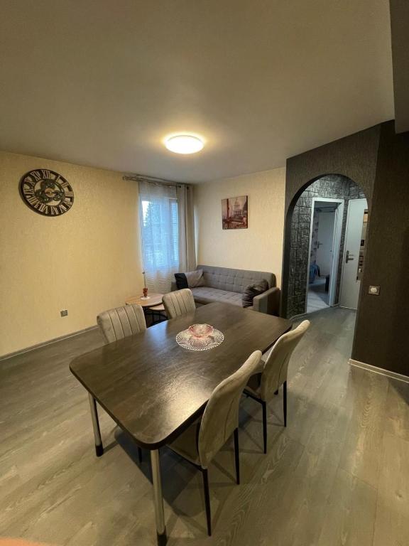 un salon avec une table et des chaises en bois dans l'établissement Appartement en résidence, à La Chaussée-Saint-Victor