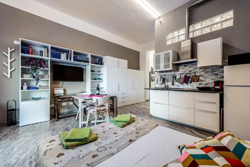 a kitchen with white cabinets and a table with chairs at Orlando's House - Pisa Downtown with View in Pisa