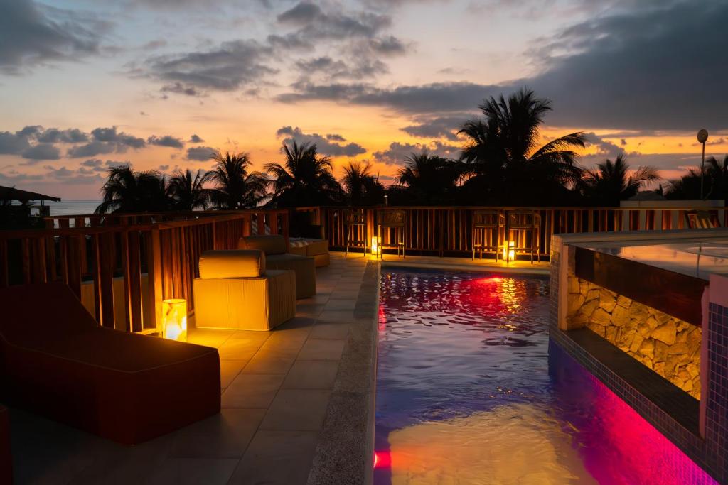 a swimming pool with a sunset in the background at Mantra Hotel Boutique in Puerto Escondido