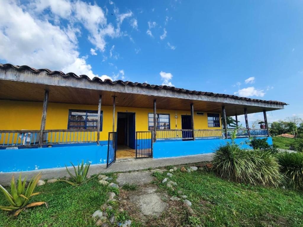 a house with a yellow and blue facade at CASA CAMPESTRE el jardín in Filandia