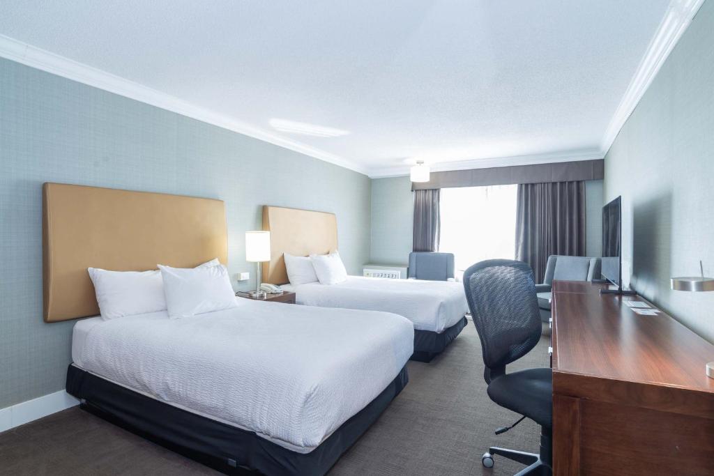 Postel nebo postele na pokoji v ubytování Sandman Hotel Vernon