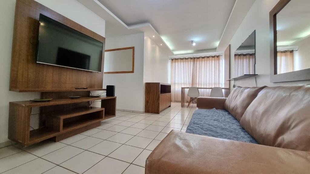 a living room with a couch and a flat screen tv at 3 bedrooms with heated pool Temporada Brasilia in Brasilia