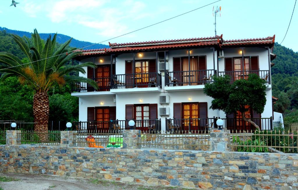 a white house with a palm tree in front of it at Maria Studios in Neo Klima