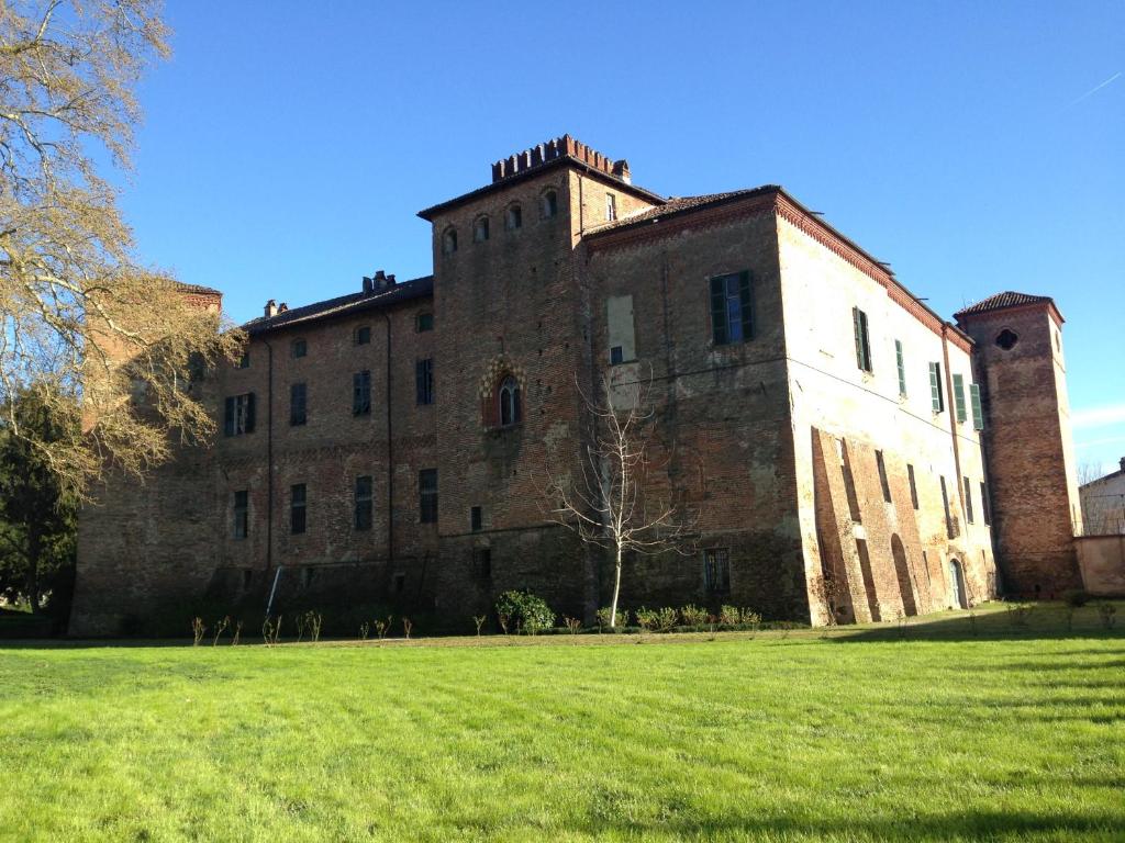 a large brick building on a field of grass at Castello Sannazzaro B&B in Giarole
