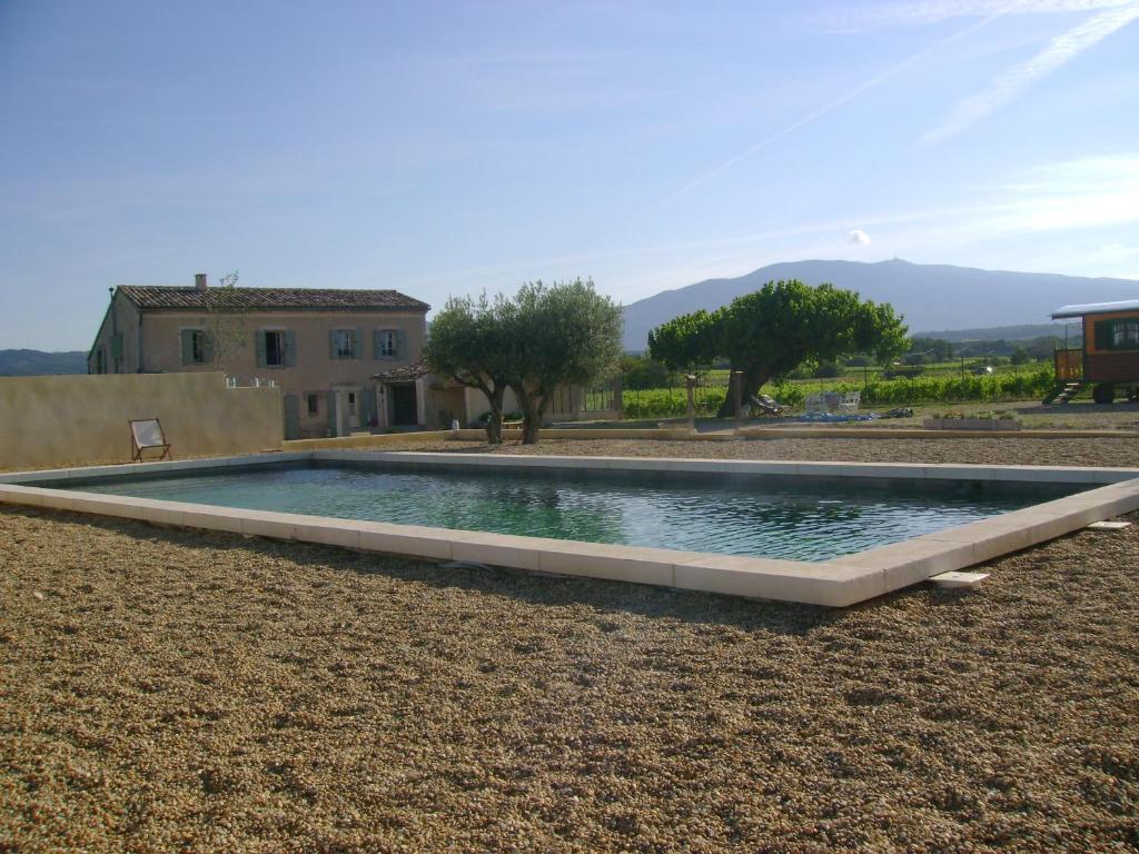 a swimming pool in a yard with a house at La Grange de Campaulise - Camping à la ferme - Hébergements - Mont Ventoux in Mazan