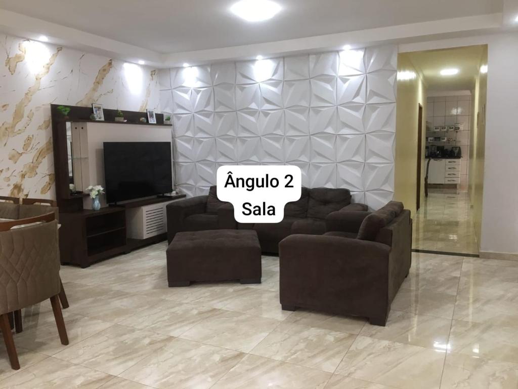 a living room with a tv and couches and asale sign at Casa luxo para a Cop 30 in Ananindeua