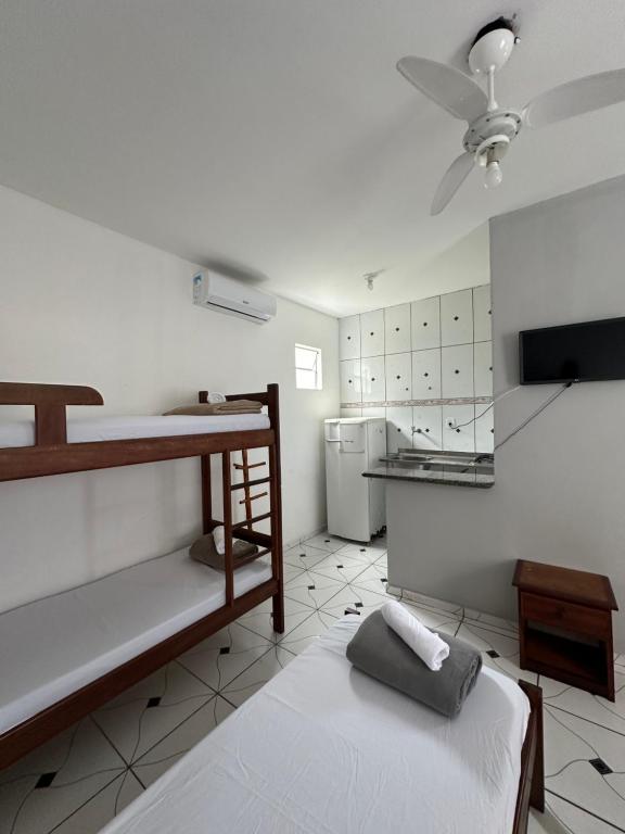 a room with two bunk beds and a kitchen at Kitnet Praia Grande in Arraial do Cabo