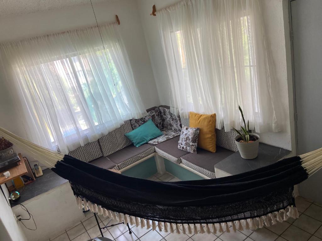 a hammock in a living room with a couch at DEPA IXTLAN alberca y cerca de playa in Santa Cruz Huatulco