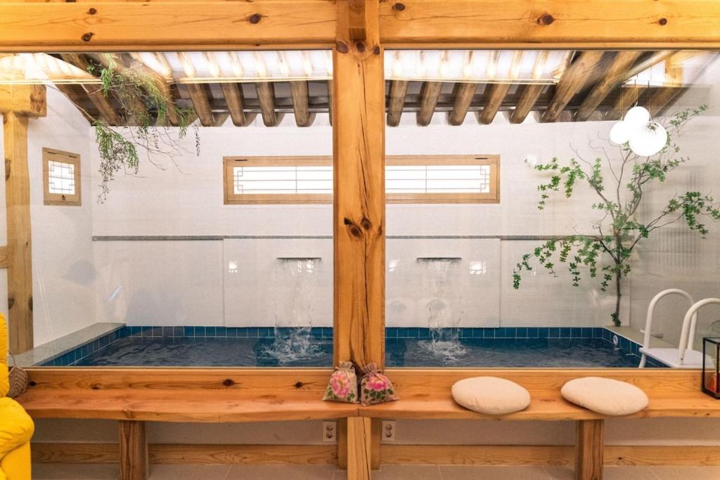 a soaking tub in a room with a window at Hanok Prince in Gyeongju