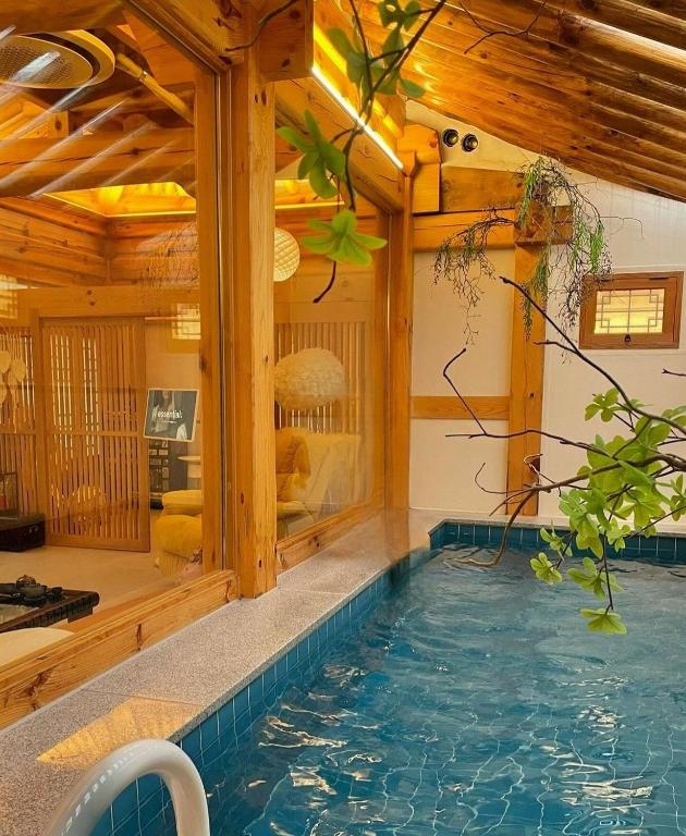 an indoor pool in a house with wooden ceilings at Hanok Prince in Gyeongju