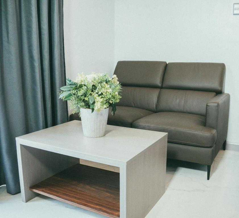 a living room with a couch and a table with a plant on it at NS Royal Hotel in Cebu City