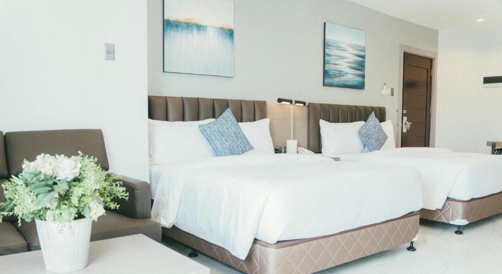 two beds in a hotel room with flowers at NS Royal Hotel in Cebu City