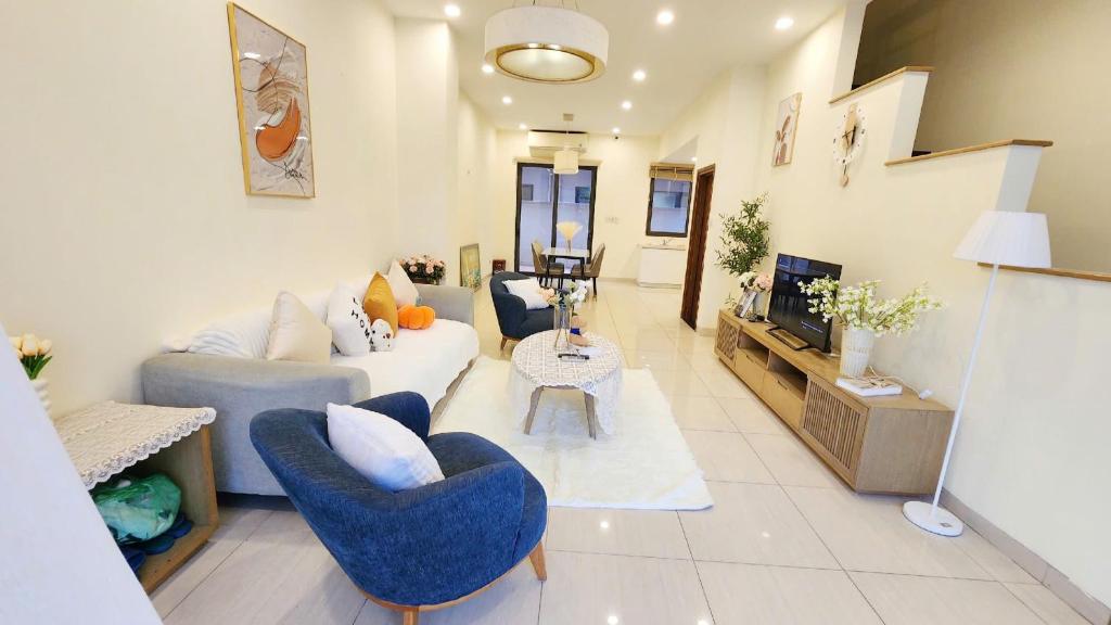 a living room with a couch and chairs and a tv at YLY Lotus in Ha Long