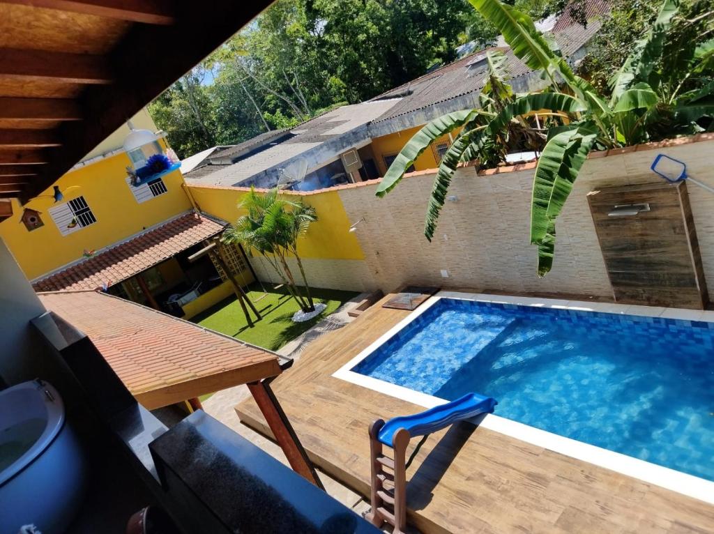 a pool with a table and a chair next to a building at Casa Vale da Paz - Massaguaçu. in Caraguatatuba