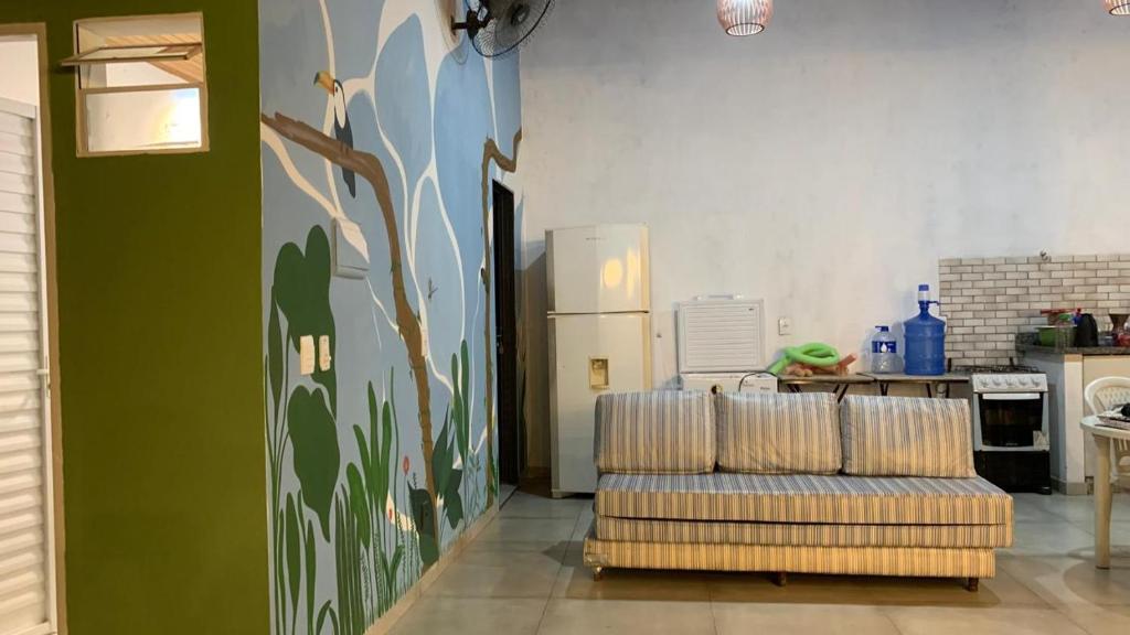 a living room with a couch and a kitchen at Casa Para temporada - casa ARASĒ in Bonito