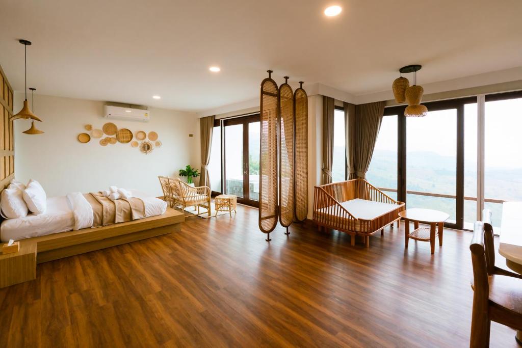 a bedroom with a bed and a living room with floor to ceiling windows at เลอค่าดอยช้าง Le Quar Doi Chang Cafe Bistro Bed & Breakfast in Ban San Pu Loei