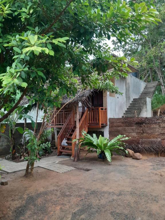 a house with a staircase and a porch with trees at Sunset view cabana in Tangalle