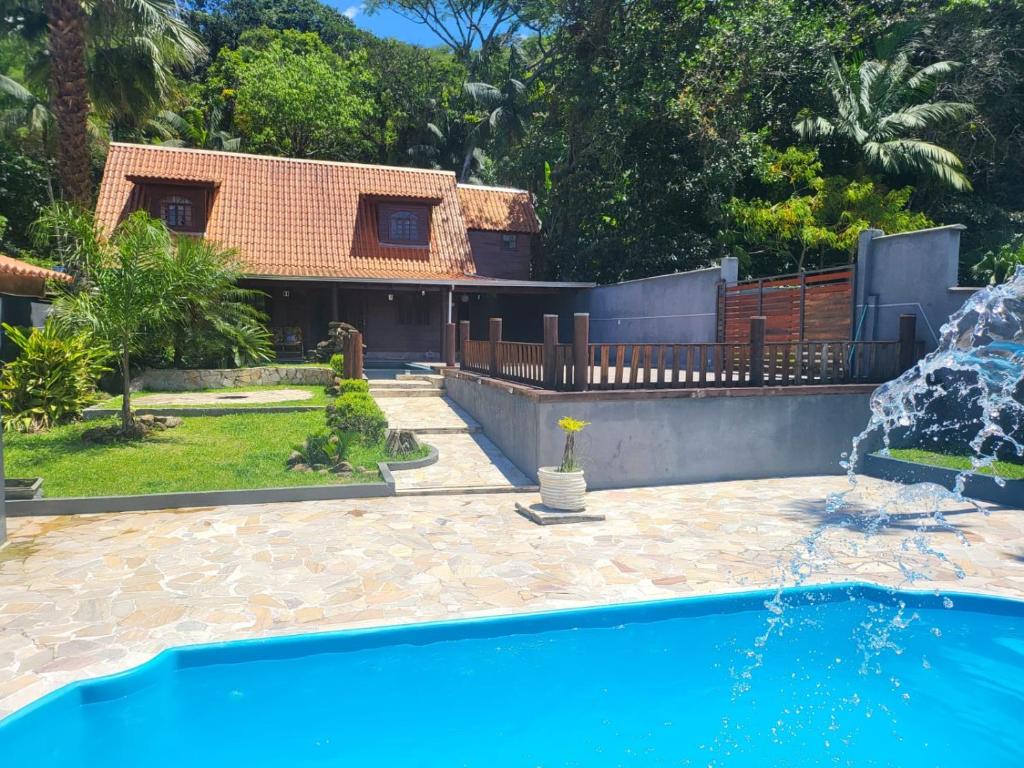 a house with a swimming pool in the yard at Recanto da Natureza in Matinhos